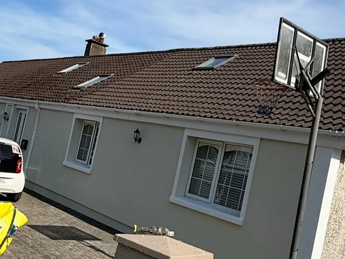 The same bungalow finished in cream render with white reveals