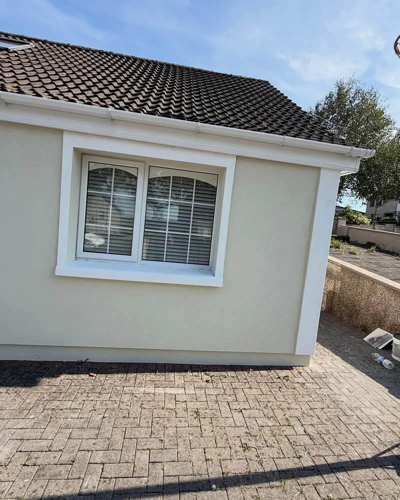 The finished window reveal, white band on cream render